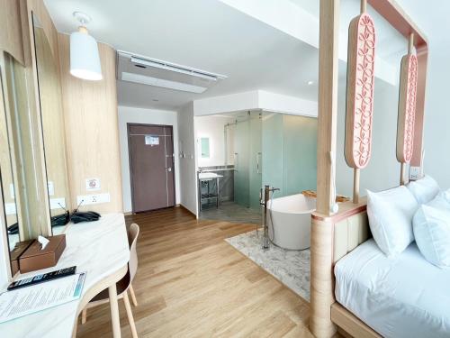 a room with a bed and a desk and a bathroom at Infinity Aonang Krabi in Ao Nang Beach