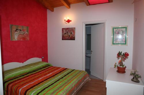1 dormitorio con cama y pared roja en Villa Monti Lepini, en Segni