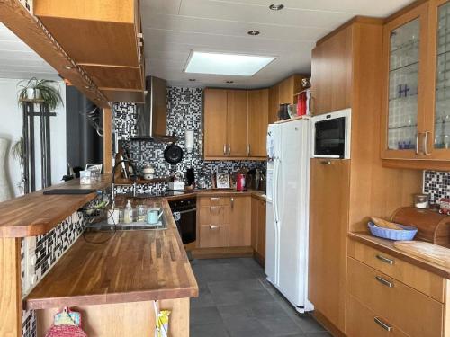a kitchen with wooden cabinets and a white refrigerator at 5 person holiday home in VÄSTRA FRÖLUNDA in Gothenburg