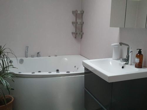 a bathroom with a bath tub and a sink at Holiday home VÄSTRA FRÖLUNDA in Gothenburg