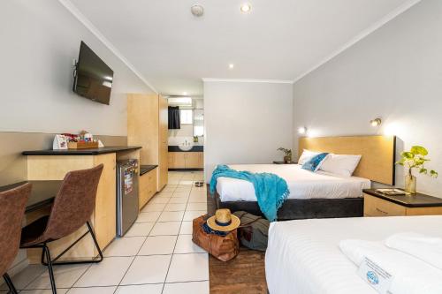 a hotel room with two beds and a kitchen at Alara Motor Inn in Mackay