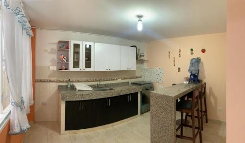 a kitchen with white cabinets and a sink and a counter at Hermoso Alojamiento in Choachí