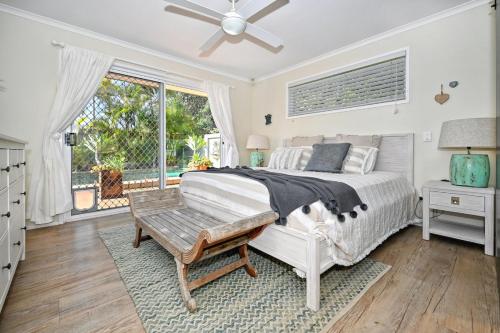 1 dormitorio con 1 cama y ventilador de techo en Driftwood Beach home, en Kawana Waters