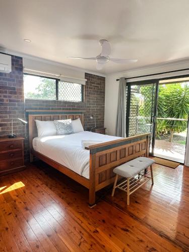 a bedroom with a large bed and a brick wall at Beach Shack in Bargara in Bargara