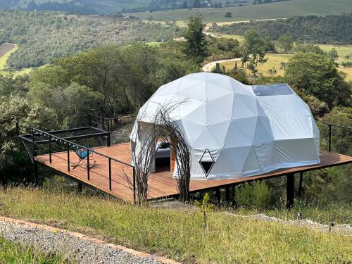una casa con una cúpula en la cima de una colina en Glamping Altos De Hayuelos, en Paipa