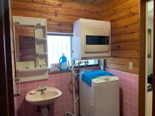 baño pequeño con fregadero y microondas en 一番館※温泉街に近く、心が落ち着く別荘地同樺順荘 en Kusatsu