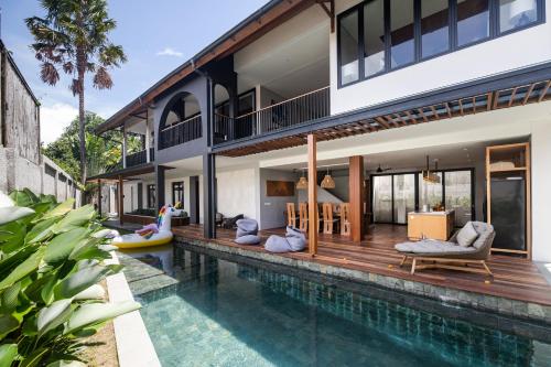 a villa with a swimming pool and a house at Villa Tamara Canggu Bali in Kerobokan