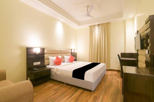 a hotel room with a bed and a desk and a television at Super Collection O Starlight in Kānpur