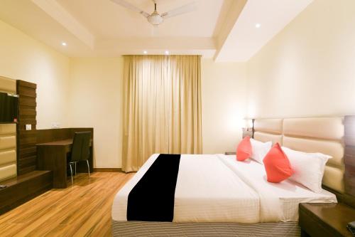 a bedroom with a bed with red pillows and a television at Super Collection O Starlight in Kānpur
