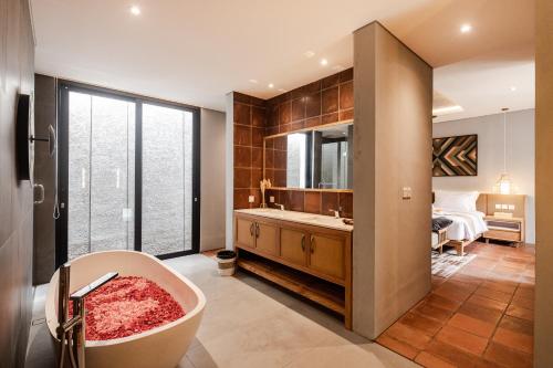 a bathroom with a bath tub and a bedroom at Villa Tamara Canggu Bali in Kerobokan
