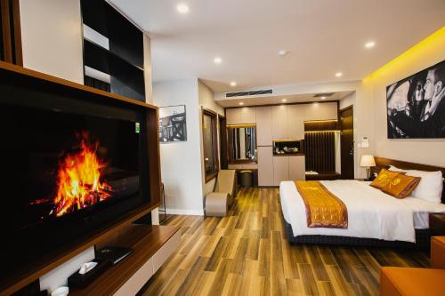 a bedroom with a fireplace and a bed and a tv at Napoli Hotel in An Khê