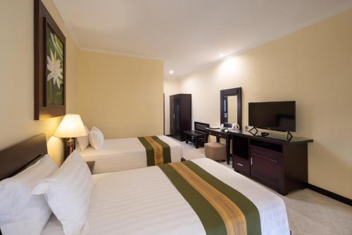 Postel nebo postele na pokoji v ubytování Adi Dharma Hotel Kuta