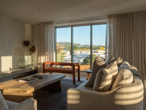 a living room with a couch and a large window at Porters Boutique Hotel in Havelock North