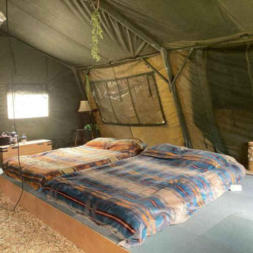 1 dormitorio con 1 cama en una tienda de campaña en Pre Hub 十勝 