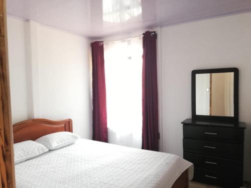 a bedroom with a bed with a mirror and a dresser at Casa Tangara in San Isidro de El General