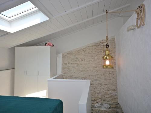 1 dormitorio con cama y pared de piedra en Maison Saint-Georges-d'Oléron, 4 pièces, 6 personnes - FR-1-246A-114 en Saint-Georges-dʼOléron