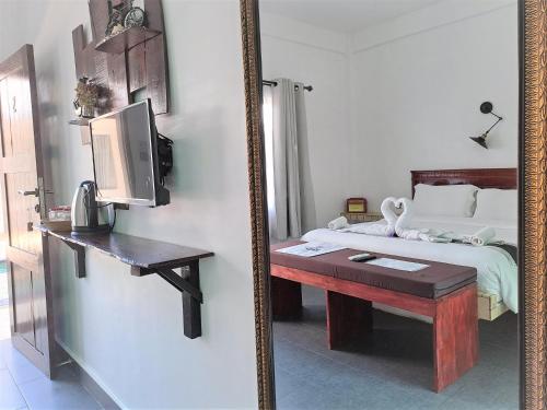 a mirror reflecting a bedroom with a bed and a table at Katara Gili, Boutique Rooms and Bungalows in Gili Trawangan