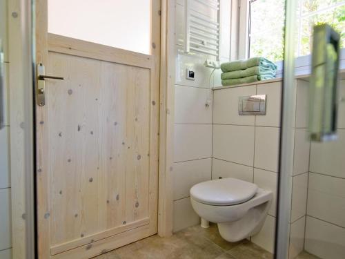 La salle de bains est pourvue de toilettes, d'une fenêtre et de serviettes. dans l'établissement Comfortable, two-story holiday houses for 5 people, Pobierowo, à Pobierowo