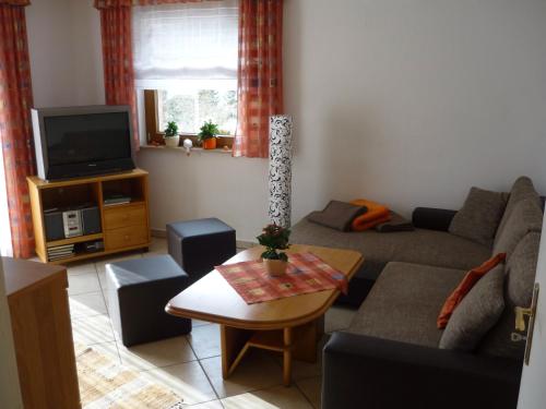 a living room with a couch and a tv at Ferienhaus Günter in Baiersbronn
