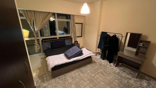 niewielka sypialnia z łóżkiem i oknem w obiekcie Prestigeo Guest House Abu Dhabi w Abu Zabi