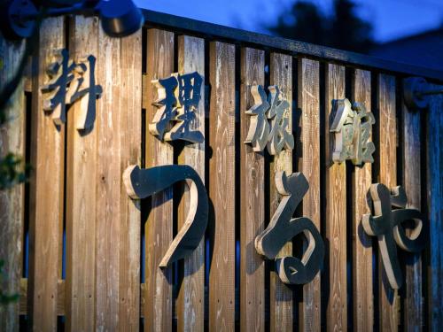 a sign with japanese writing on a wooden fence at Tsuruya / Vacation STAY 59066 in Miyaji