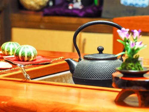 a black tea kettle on a table with watermelons at Tsuruya / Vacation STAY 59065 in Miyaji