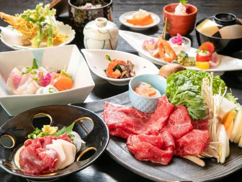 una mesa con platos de comida y tazones de comida en Tsuruya / Vacation STAY 59065 en Miyaji