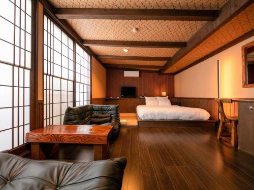 MiyajiにあるTsuruya / Vacation STAY 59065のベッド、ソファ、テーブルが備わるホテルルームです。