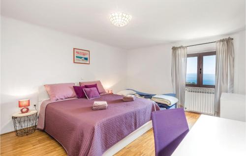 um quarto branco com uma cama roxa e uma janela em Amazing Apartment In Icici With Kitchen em Ičići
