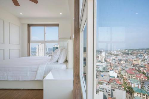 een slaapkamer met een bed en uitzicht op de stad bij Homestay Hạ Long 3 phòng ngủ view biển in Ha Long