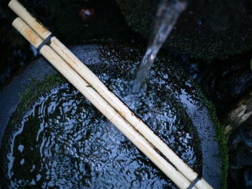 a pair of chopsticks sitting on a bowl with water at Tsuruya / Vacation STAY 59052 in Miyaji