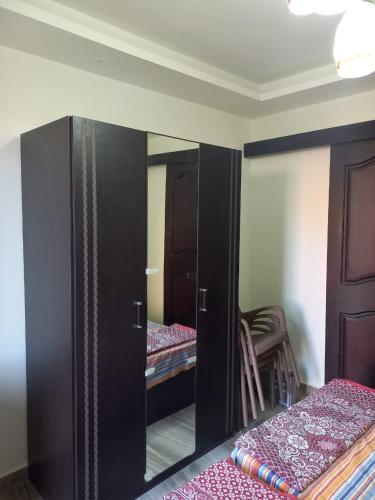 a room with a closet with a mirror and two beds at شاليهات للمصايف بقرية جولف بورتو مارينا الساحل الشمالي in El Alamein