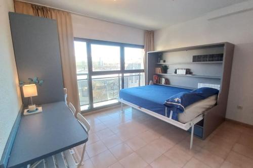 プラヤ・デアロにあるMini-apartament cèntric a Platja d'Aroのベッドルーム(青いベッド1台、大きな窓付)