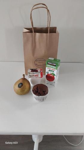 einen Tisch mit einer Tasche, einem Muffin und einem Cupcake in der Unterkunft 66 Chaucer B&B with Complimentary Breakfast to Go Bag in Cambridge