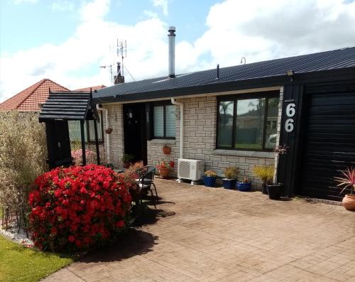 a house with red flowers in front of it at 66 Chaucer B&B with Complimentary Breakfast in Cambridge