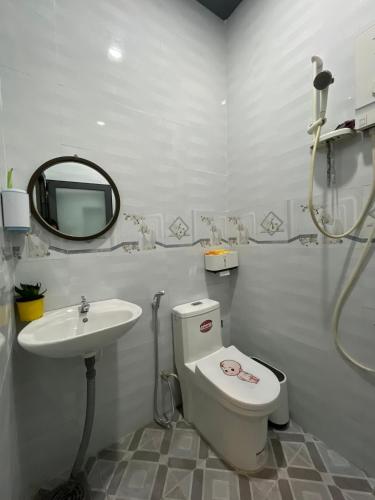 y baño con aseo, lavabo y espejo. en HO GIA AN Home - Căn hộ ngay Trung Tâm, en Can Tho
