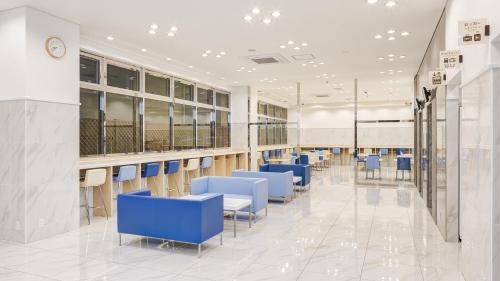 a waiting room with blue chairs and tables at Toyoko Inn Kyoto Nijojo Minami in Kyoto