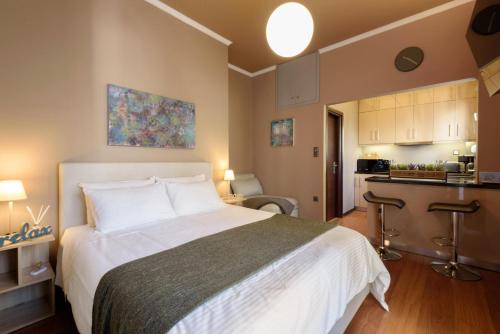 een slaapkamer met een groot bed en een keuken bij Armoniko in Athene