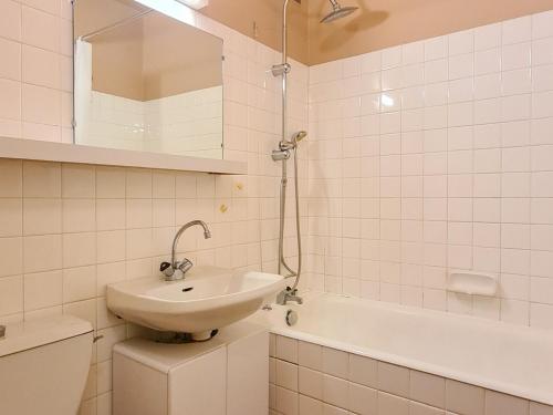 une salle de bain blanche avec un lavabo et une baignoire dans l'établissement Studio confort avec balcon sud, proche pistes et commerces, équipements pour 4 personnes - FR-1-425-183, à Flaine