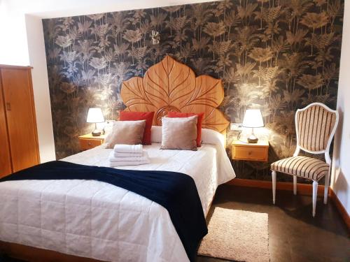 a bedroom with a large bed and two chairs at Paloma entorno natural in Oiartzun