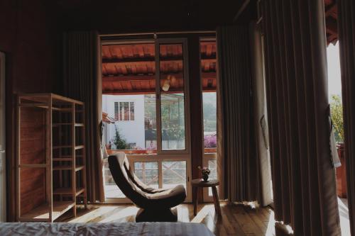 a room with a chair in front of a window at Samma Stay Tam Đảo in Tam Ðảo