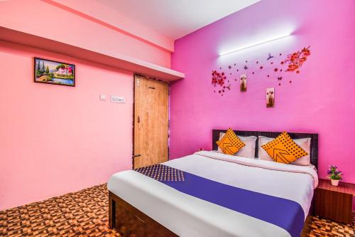 a bedroom with a pink wall and a bed at SPOT ON M R Plaza in Bhubaneshwar