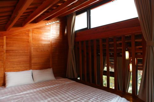 a bed in a room with a large window at Samma Stay Tam Đảo in Tam Ðảo