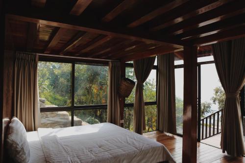 een slaapkamer met een bed en een groot raam bij Samma Stay Tam Đảo in Tam Ðảo