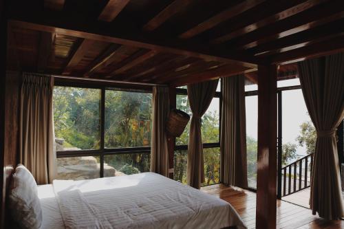 a bedroom with a bed and a large window at Samma Stay Tam Đảo in Tam Ðảo