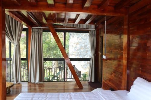 a bedroom with a bed and a large window at Samma Stay Tam Đảo in Tam Ðảo
