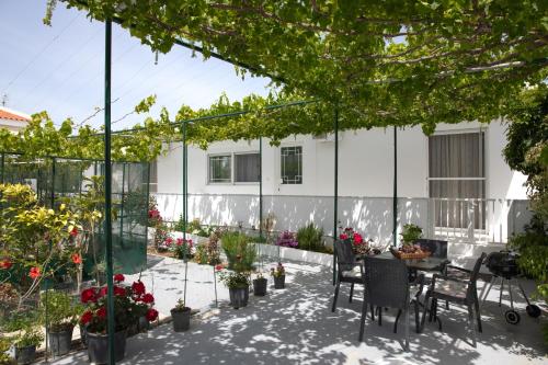 a patio with a table and chairs and potted plants at Iliana's House in Zipárion