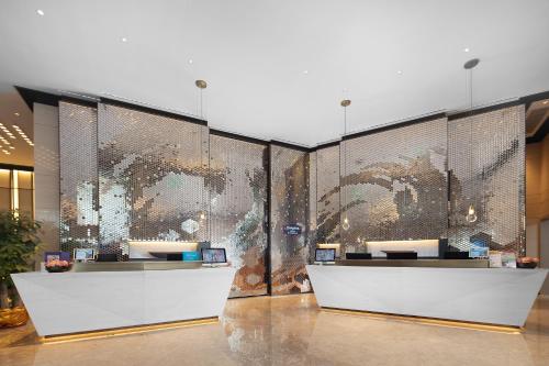 a lobby with a large wall of glass at Hampton by Hilton Shenzhen North Station in Shenzhen