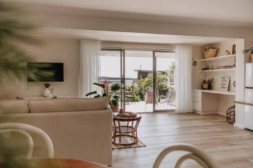 a living room with a couch and a table at Olga and Alma - The Coastal Retreat in Pambula Beach