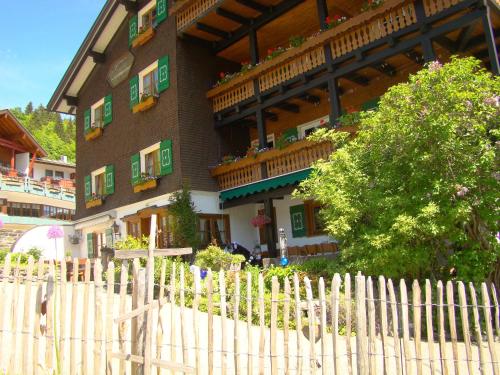 a building with a wooden fence in front of it at Gästehaus Fritz in Mittelberg